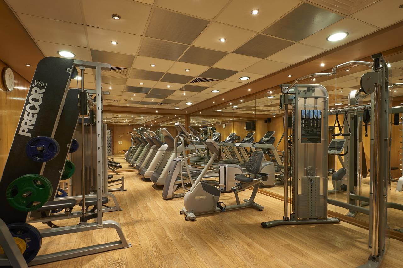 โรงแรมซาเฟอไคโร Giza ภายนอก รูปภาพ The photo shows a well-equipped gym with various exercise machines. There are several cardio machines lined up, including treadmills, stationary bikes, and elliptical trainers. Strength training equipment is also present, including a multi-functional
